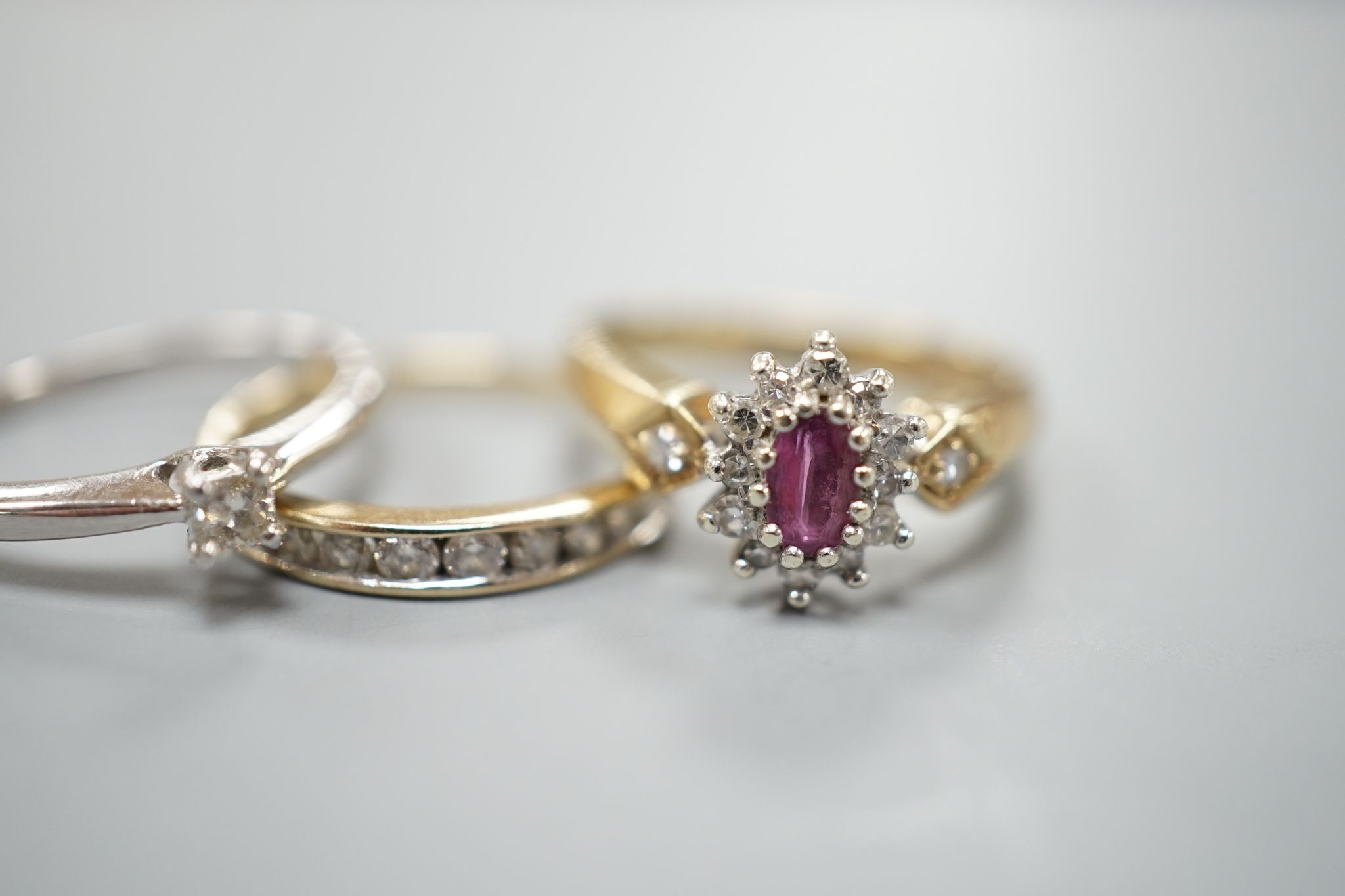 Three assorted 9ct gold and gem set dress rings including a solitaire diamond ring, size I, gross weight 5.8 grams.